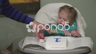 Mom teaches baby how to do finger painting for 1 year old birthday art project.