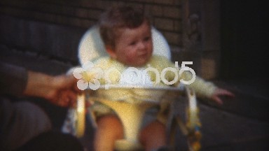 1948: Parent Playing With Unsure Baby in Bouncing Chair Contraption