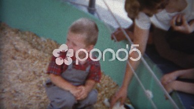 1954: Mom teaching kids at petting zoo about rabbits and sheep.