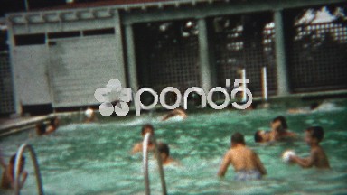1954: Boy splashing in lifejacket while water polo breaks out in pool.