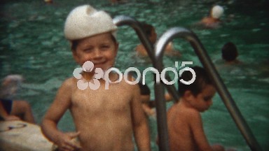 1954: Boy wearing deflated water polo ball on head as a hat.