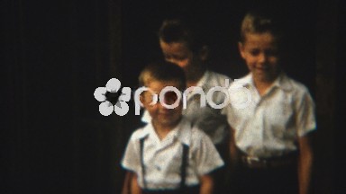 1954: Cute baby brothers dress in white shirts and black pants.