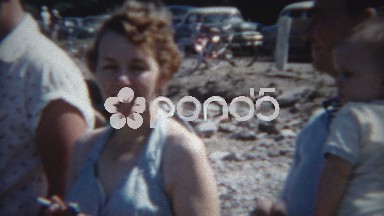 1954: Women annoyed at beach while family awkwardly smiles.