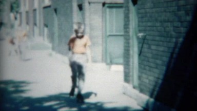 1954: Boys in Orange Practicing Rollerskating on Chicago City Streets