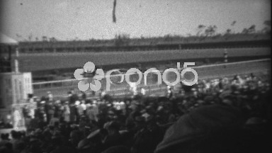 1935: Crowd at horse track race watching horses come out to compete. HIALEAH,