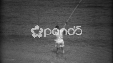 1936: Kid beach shore fishing on gulf bay waters with long pole. MIAMI, FLORIDA
