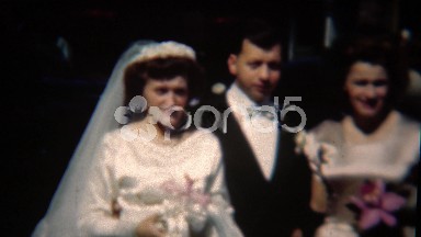 1954: Groom being funny at wedding sticks tongue out with grin mocking.