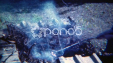1953: Girl cooking hotdog over wood burning campfire hobo style. PITTSBURG