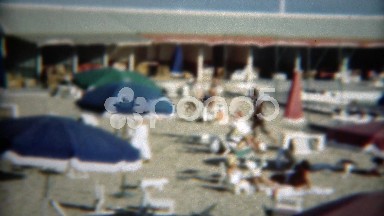 1949: Poolside pan of loungers enjoying summer sun colorful umbrellas. ERIE,