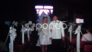 1966: Young couple walking down wedding aisle and kissing at altar. CINCINNATI,
