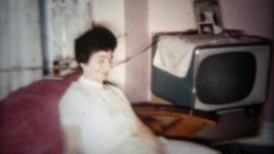 1961: Happy girl and family hanging out in front of TV in living room. PLANO,