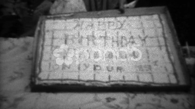 1961: Grandpa celebrating 85th birthday party cutting large square cake.