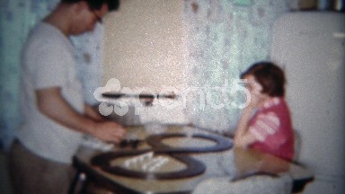 1962: Dad building slot car race track on kitchen table Christmas mourning.
