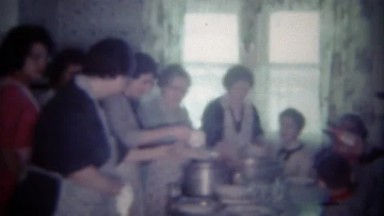 1963: Large family crowded into kitchen dining table for holiday feast. BUFFALO,