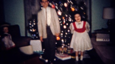 1961: Brother sister show off twist dancing skills in front of Christmas tree.
