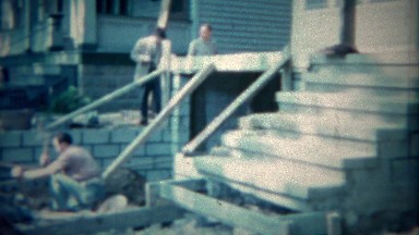 1963: Man using sledge hammer remodeling home garage construction. BUFFALO, NEW