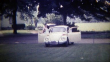 1971: Family arrives in Volkswagen Beetle Bug car parks on lawn. DES MOINES,