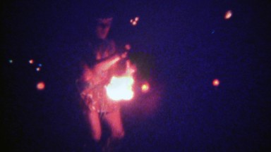 1973: Night time fire spin dancing flame torch twirl ceremony. HONOLULU, HAWAII