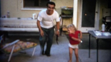 1963: Nerdy eyeglasses dad dancing with toddler around the back porch. BUFFALO,