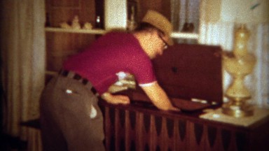 1966: Dad plays music chest vinyl record player for guest's listening pleasure.