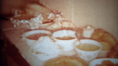 1966: Table of Party Food Spread with Chips Dips Breads Olives Grapes and Soup