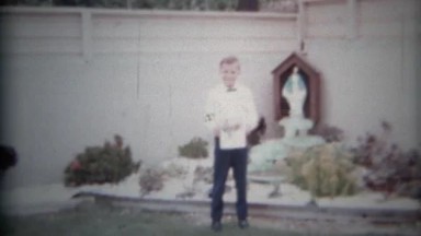 Proud Boy Beside Backyard Grotto Stands Still as a Statue