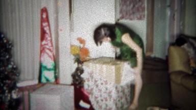 1966: Girl gets giant boxed stuffed animal toy gag gift for Christmas. BUFFALO,