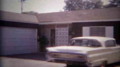 1965: White classic car parked in driveway of modest suburban home. SAN DIEGO,