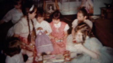 1962: Girlfriends in long dresses open birthday presents. BUFFALO, NEW YORK