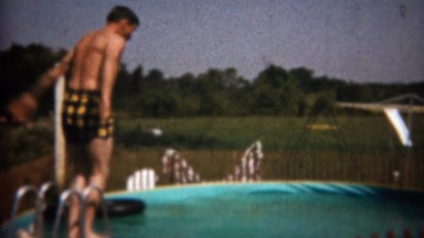 1961: Man dives into small above ground swimming pool. BUFFALO, NEW YORK