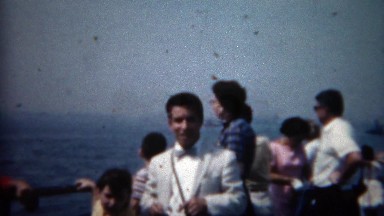 1961: Cool guy immigrant in white suit on boat coming to America. ELLIS ISLAND,