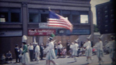 1962: American flag leading 4th of July parade green marching band. BUFFALO, NEW