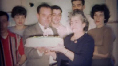1959: Family with grandma's giant round white birthday cake. BUFFALO, NEW YORK