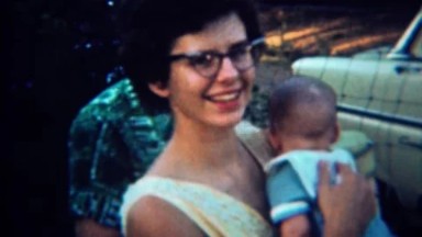 1959: 50's style mother shows off cute baby boy. PORTLAND, OREGON