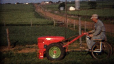 1951: Man heavy duty riding lawn mower cutting the grass. LINCOLN, NEBRASKA