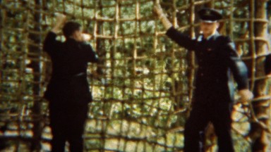 1966: Formal military uniformed cadet climbing up rope cargo net. U.S. AIR