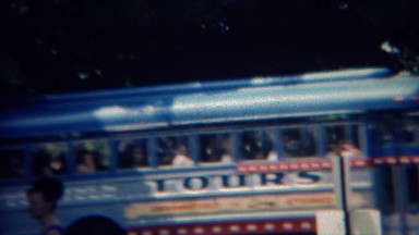 1968: Colorful retro style tour bus passes city park patrons. GETTYSBURG, PENN.