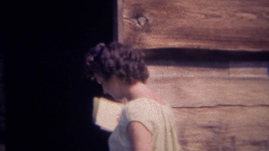 1966: Curly haired farm maiden enters wood cabin building structure. GREAT SMOKY