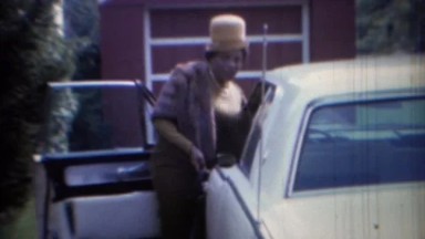 1967: African American mother in yellow top hat enters car in Carmel, Indiana