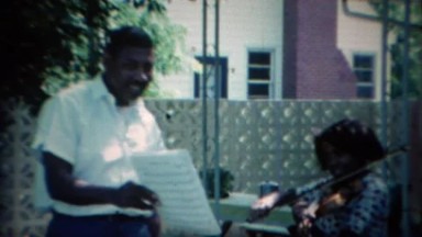 1967: African American daughter practicing violin with her father. CARMEL,