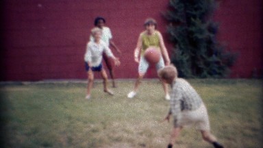 1969: Multicultural kids playing backyard dodgeball. CARMEL, INDIANA