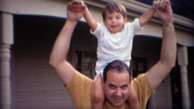 1969: Happy Caucasian Boy Riding on Father's Shoulders in Carmel, Indiana