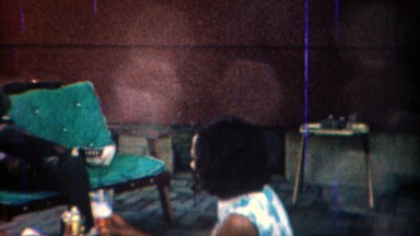 1969: Surprised African women drinking glass draft alcohol beer.