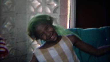 1969: Silly African girl performing in homemade halter top.