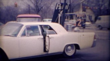 1971: African girl exits white Lincoln car suicide door backseat.