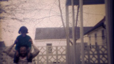 1971: African dad daughter playing on outdoor back patio.