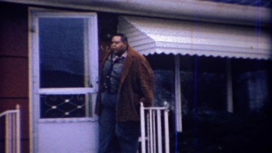 1971: Overweight African man leaving party in classic Chrysler Car.