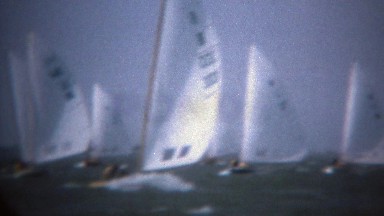 1979: Sailboating rail boat tacking across win switching sail direction.