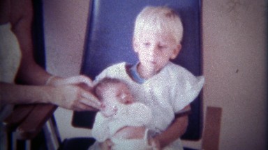 1978: Blonde haired brother holds newborn baby sister.