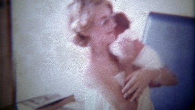1978: Fashionable 70's mother holding newborn baby.